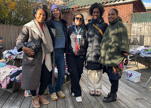 Five women standing on a deck dressed in winter clothing